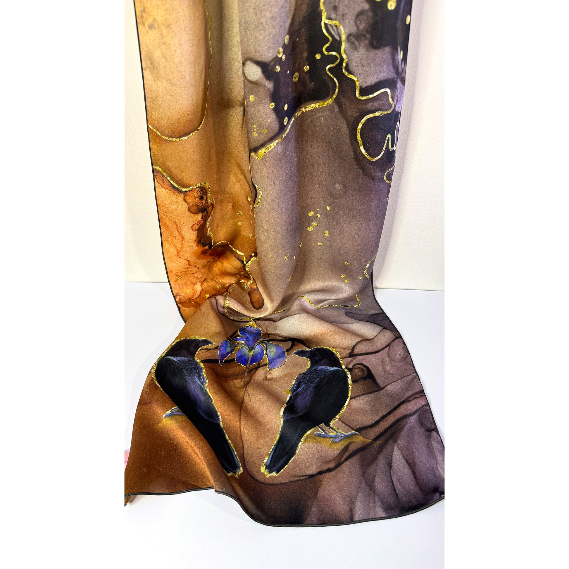 Artistic depiction of crow birds and a blue iris flower on a textured surface of a silk scarf, with a white background. Unique silk scarf suitable for client appreciation gifts and luxury corporate gifts. 