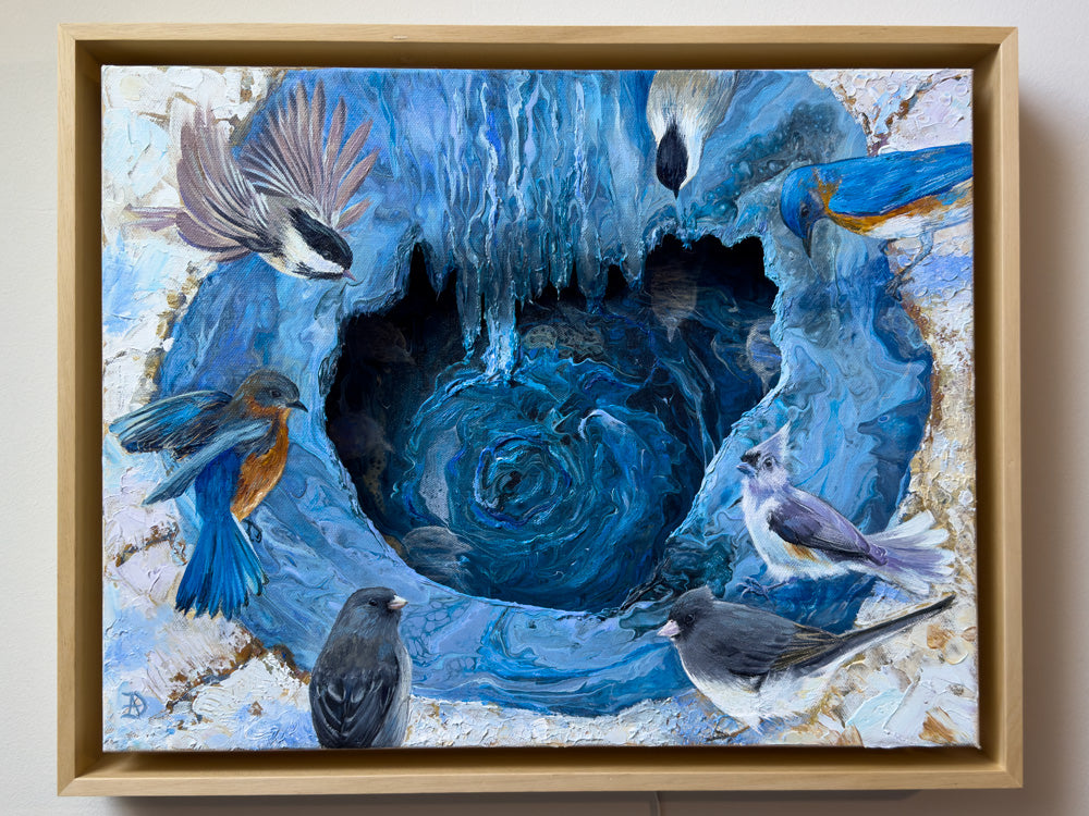 Framed artwork with backyard birds, such as bluebirds, juncos, titmice and chickadees, gathered around a small pond. The painting has abstract elements and an overall blue tonality.