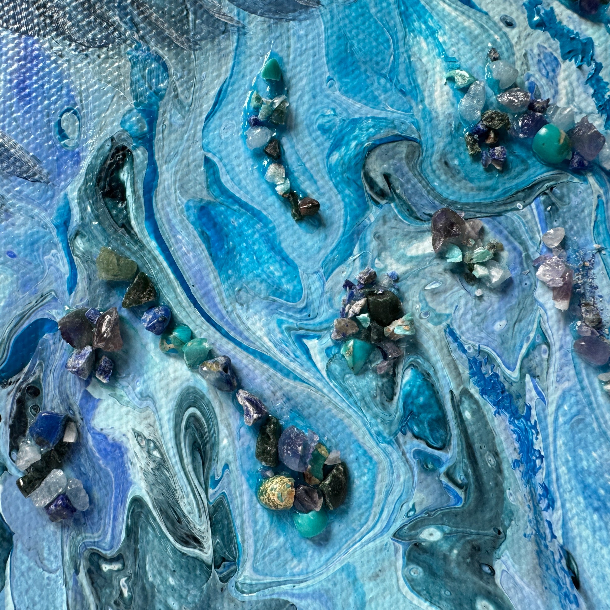 Artistic depiction of swirling blue and gray patterns with embedded stones