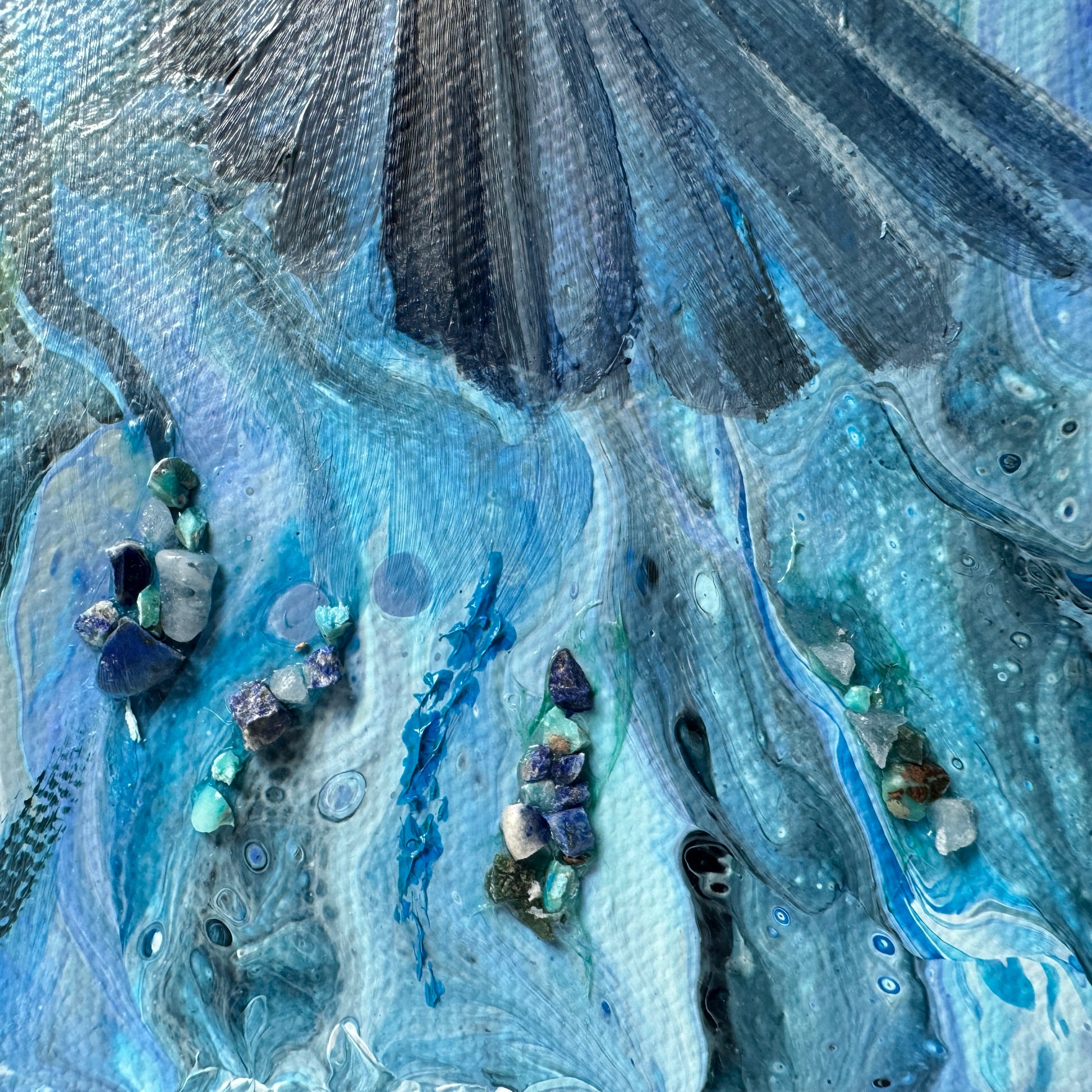Close-up of a textured blue and gray surface with embedded stones