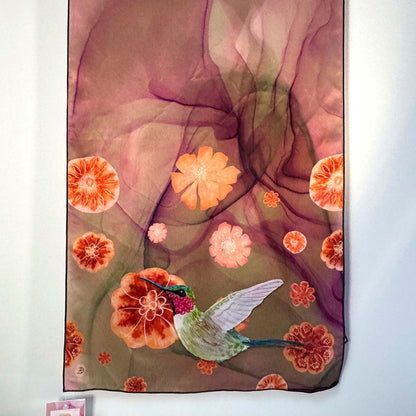 Decorative silk scarf with floral and hummingbird design against a white background