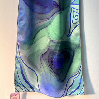 Colorful scarf with abstract blue and teal design on a white background