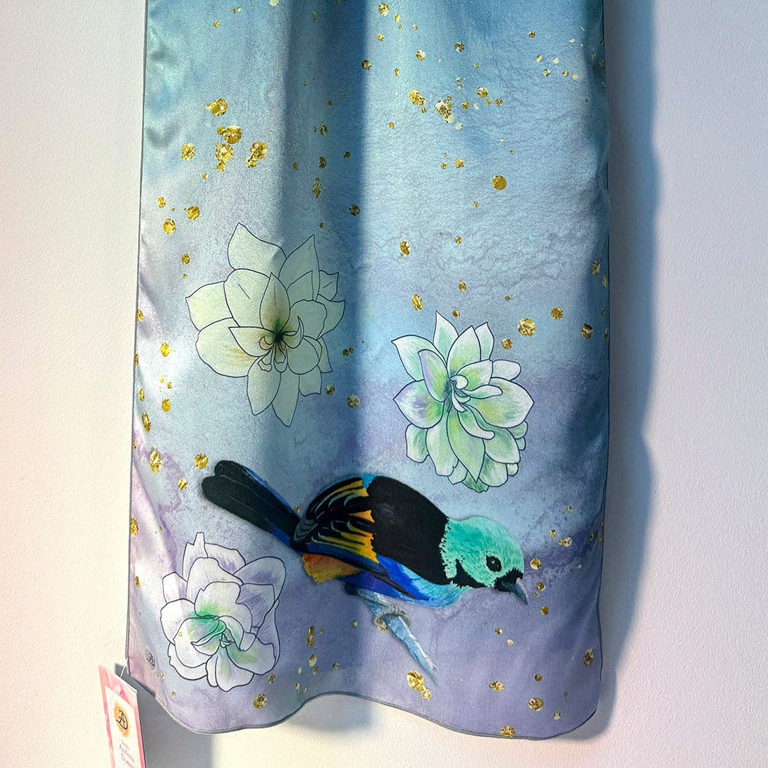 Blue silk scarf with floral and tanager bird design on a white background
