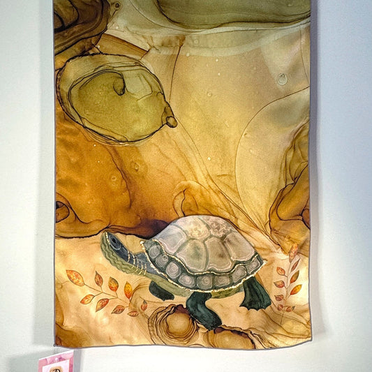 Decorative silk scarf with a turtle design on a beige and green abstract background